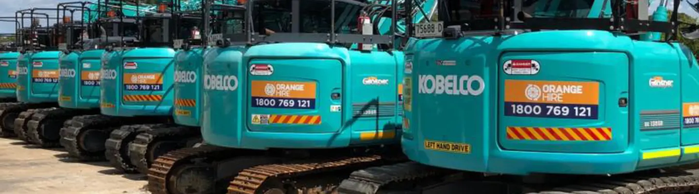 Multiple excavators displayed at a construction site, showcasing equipment used for digging and barrier installation work.