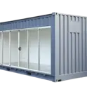 Modern outdoor container room with large sliding glass doors and grey metal exterior.