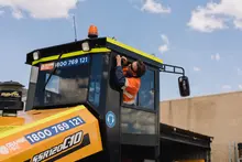 A man operating machinery, carefully cutting materials at a construction or industrial worksite.