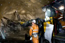 Excavators and heavy equipment digging underground at a construction site for barrier foundation or utility installation.