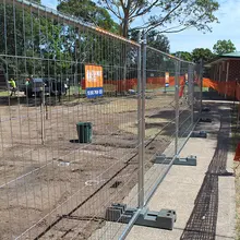 Temporary fencing installed around an active work area to restrict access and enhance on-site safety for workers and visitors.