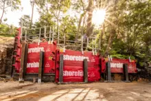 Temporary post and panel wall system enclosing a construction site to enhance safety, security, and dust control.