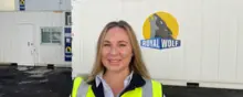 Manager standing in front of shipping containers ready for deployment, used for site storage, offices, or safety equipment housing.