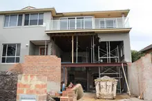 Partially built construction structure supported by props, using lightweight materials for framing and stabilization.